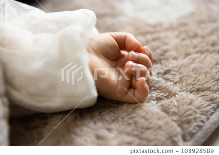 The right hand of an infant taking a nap in the living room The right hand of an infant taking a nap in the living room 103928589