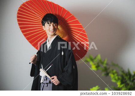 A man in a hakama with a crest, a Japanese umbrella A man in a hakama with a crest, a Japanese umbrella 103928692
