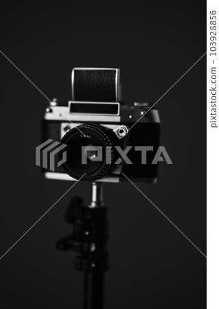 Black and white photo of a retro camera. Shooting on film. Black and white photo of a retro camera. Shooting on film. 103928856