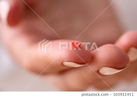 Red heart on the finger of a woman's hand. Concept. 103931451