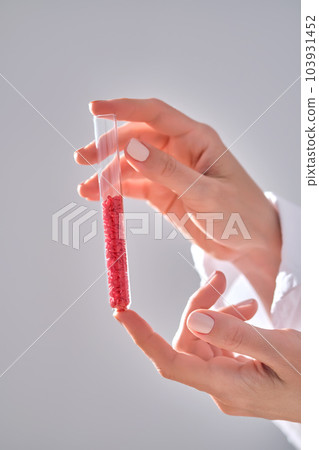 The girl is holding a test tube with red hearts. The girl is holding a test tube with red hearts. 103931452
