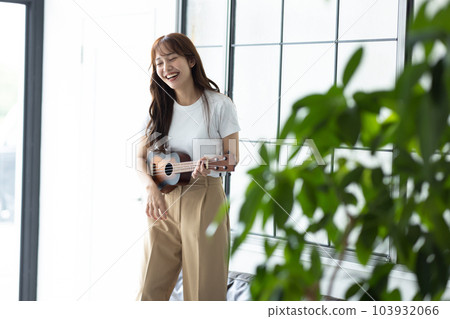 在她的房間裡彈尤克里裡琴的女人 103932066