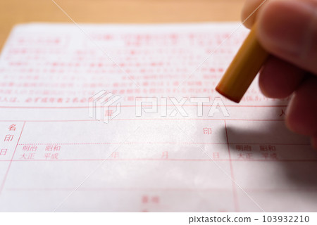 Hand holding a stamp on an official document Sealing a registered seal 103932210