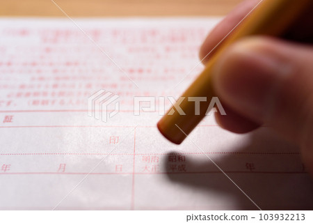 Hand holding a stamp on an official document Sealing a registered seal 103932213