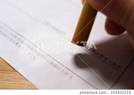 Hand holding a stamp on an official document Sealing a registered seal Trimming up Hand holding a stamp on an official document Sealing a registered seal Trimming up 103932219