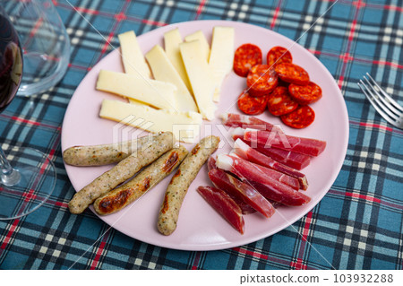 Slicing of pieces of sausage, hard cheese, fried sausages and smoked meat 103932288