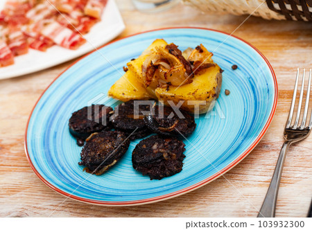 Catalan blood sausage with garnish of baked potatoes Catalan blood sausage with garnish of baked potatoes 103932300