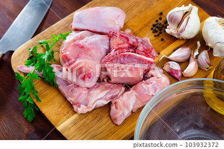 Delicious cutting rabbit meat with spices and herbs on kitchen board 103932372
