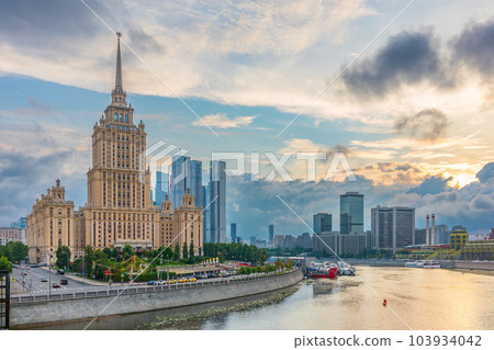 High-rise stalinist building near river at summer sunset in Moscow, Russia. Historic name is Hotel Ukraine. 103934042