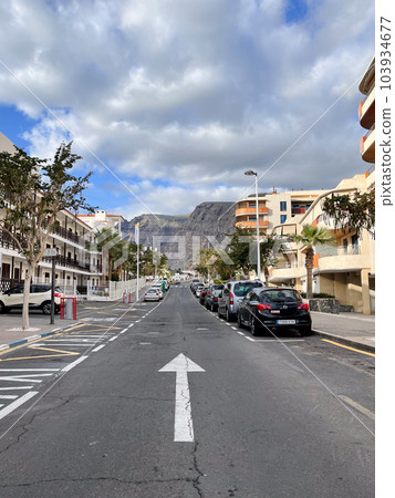 One side road with the road sign on it. Street with parallel parked cars. One side road with the road sign on it. Street with parallel parked cars. 103934677