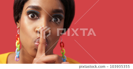 Secret hush. Keep quiet. Stop talking. Disturbed scared woman with colorful face makeup warning with shh finger gesture isolated on pink empty space background. 103935355