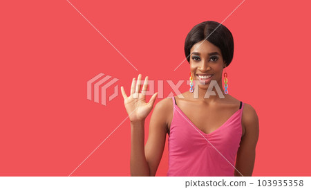 Hello gesture. Welcoming greeting. Friendly meeting. Cheerful smiling woman waving hand hi isolated on pink empty space background. Hello gesture. Welcoming greeting. Friendly meeting. Cheerful smiling woman waving hand hi isolated on pink empty space background. 103935358
