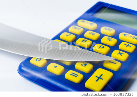 Knife blade placed on euro coin, calculator. Concept cutting rates, money business, crime. Macro. 103937325