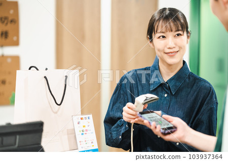 用二維碼付款的男士和掃碼的女店員 用二維碼付款的男士和掃碼的女店員 103937364