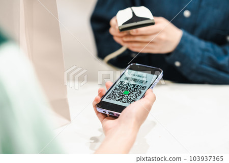 用二維碼付款的男士和掃碼的女店員 103937365