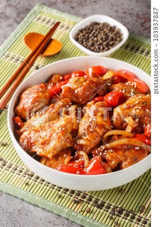 Black pepper chicken with juicy tender fillet, crisp vegetables and a rich savory black pepper sauce closeup on the bowl. Vertical 103937887