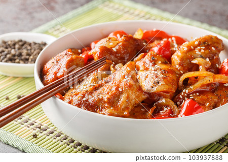 Stir-fried black pepper chicken with vegetables in a spicy sauce close-up in a plate. Horizontal 103937888