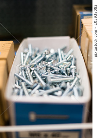 Small thin metal nails, hardware, screw lying in a store container. 103938082