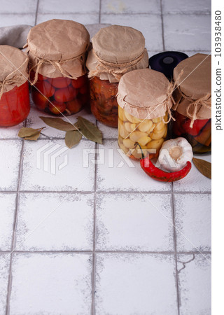 Pickled vegetables in glass jars. 103938480
