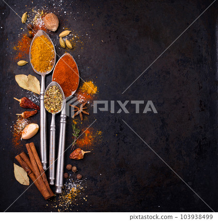 Different spices and herbs on a black background Different spices and herbs on a black background 103938499