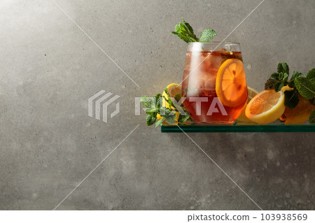 Cocktail with ice, lemon and mint on the background of the grey concrete wall. Cocktail with ice, lemon and mint on the background of the grey concrete wall. 103938569