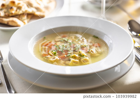 Chicken or rooster stock soup with tortellini Chicken or rooster stock soup with tortellini 103939982