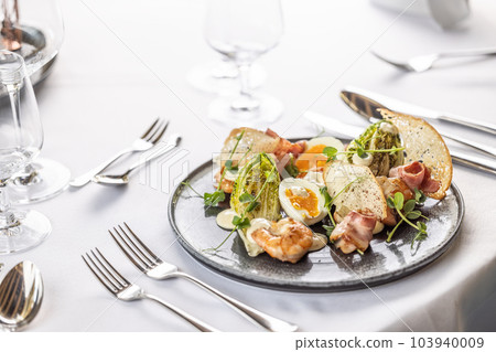 Luxury restaurant serves a modern twist on the classical ceasar salad on a dark plate Luxury restaurant serves a modern twist on the classical ceasar salad on a dark plate 103940009