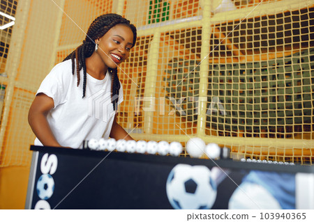 Black girl in a white t-shirt. Couple playing a table football 103940365