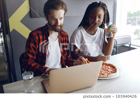 Students create a new project. Couple working in a office. Black girl in a white t-shirt 103940426