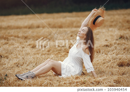 Woman in a summer field. Lady in a white dress. Girl on a sunset background. 103940454