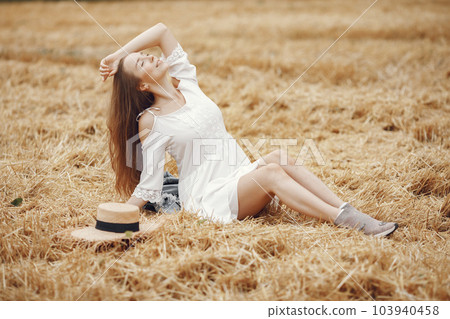 Woman in a summer field. Lady in a white dress. Girl on a sunset background. 103940458