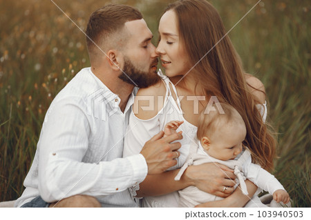 Parents with daughter. Family in a field. Newborn girl. Woman in a white dress. Parents with daughter. Family in a field. Newborn girl. Woman in a white dress. 103940503