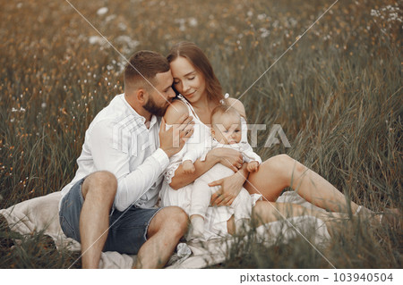 Parents with daughter. Family in a field. Newborn girl. Woman in a white dress. Parents with daughter. Family in a field. Newborn girl. Woman in a white dress. 103940504