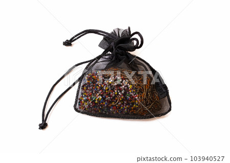 Decorative bag with beads on a wooden table 103940527