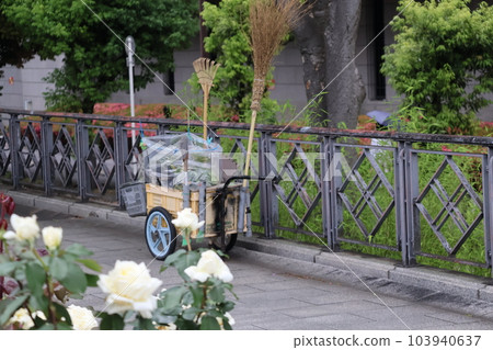 帶清潔工具拖車的帶白玫瑰花和綠色植物的景觀長廊公園 103940637