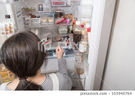 [Housewife taking out food from the refrigerator] 103940764