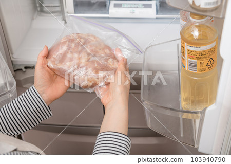 [Housewife serving chicken seasoned for deep-frying from the refrigerator] 103940790