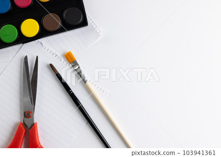 Close up of paints, paper, scissors and brushes with copy space on white background Close up of paints, paper, scissors and brushes with copy space on white background 103941361