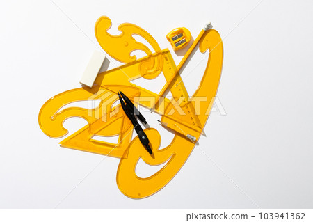 Close up of yellow rulers, compass and sharpener on white background Close up of yellow rulers, compass and sharpener on white background 103941362