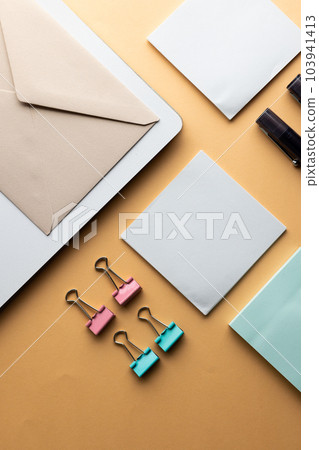 Flat lay of black pens, envelope, paper clips and memo notes with copy space on yellow background 103941413