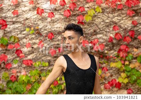 Biracial transgender man looking away, with rocks and leaves in background 103941821