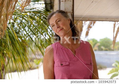 Thoughtful caucasian senior woman looking away while sitting in balcony at cottage, copy space 103942073