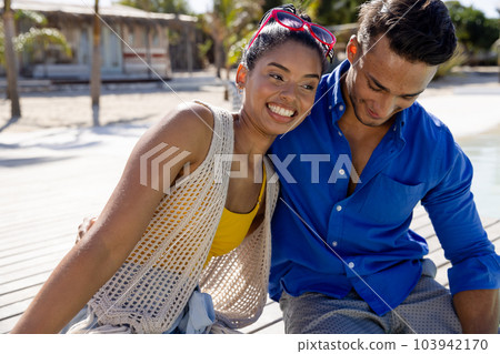 Cheerful caucasian young couple relaxing and sitting at tourist resort during sunny day Cheerful caucasian young couple relaxing and sitting at tourist resort during sunny day 103942170