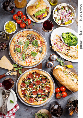 Big dinner with pizza and sandwiches 103942699