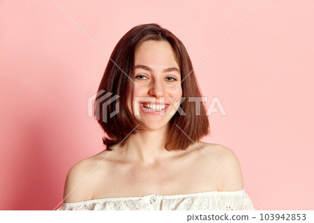 Happiness and joy. Portrait of beautiful young brunette woman looking at camera, cheerful smiling, laughing against pink studio background Happiness and joy. Portrait of beautiful young brunette woman looking at camera, cheerful smiling, laughing against pink studio background 103942853