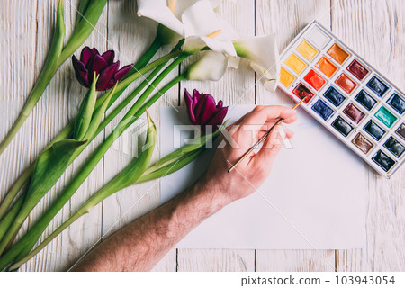 Palette of watercolor paints, brushes and paper for a water color on wooden background, close up. Flat lay, spring background with copy space Palette of watercolor paints, brushes and paper for a water color on wooden background, close up. Flat lay, spring background with copy space 103943054