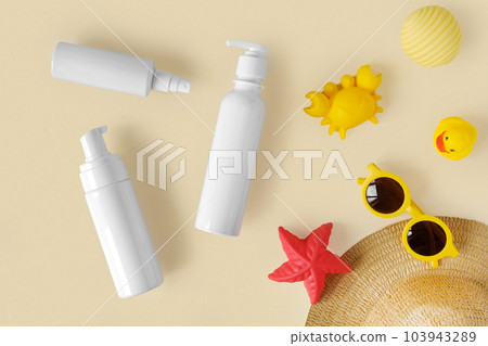 Sunscreen lotion tube on neutral background. Plastic bottle of sun protection and kids sunglasses and sandbox toys on beige table. Children skin care concept. Sunscreen for children. Baby Cosmetic Sunscreen lotion tube on neutral background. Plastic bottle of sun protection and kids sunglasses and sandbox toys on beige table. Children skin care concept. Sunscreen for children. Baby Cosmetic 103943289