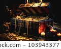 An realistic open pirate's treasure chest with gold coins and jewelry overflowing onto the wooden floor in the captain's cabin on board a pirate ship, blurred background - Generative AI 103943377