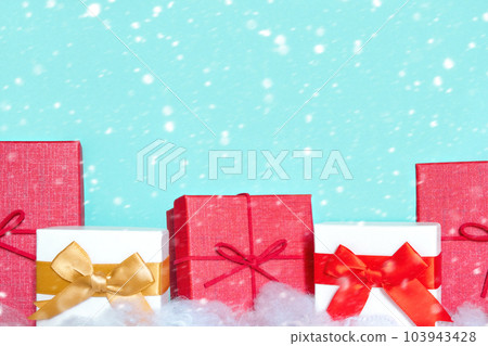 Closeup of different colorful gift boxes in a row with beautiful decorations and bows isolated on Light Blue. Gift boxes on a white table stand in a row. Christmas, New Year presents Closeup of different colorful gift boxes in a row with beautiful decorations and bows isolated on Light Blue. Gift boxes on a white table stand in a row. Christmas, New Year presents 103943428