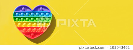 Popit - Colorful antistress sensory toy for child. New popular Silicone toy - pop it on yellow background. Rainbow color. Top View. Copy space. Trend of summer 2021. Entertainment for children. Banner Popit - Colorful antistress sensory toy for child. New popular Silicone toy - pop it on yellow background. Rainbow color. Top View. Copy space. Trend of summer 2021. Entertainment for children. Banner 103943461